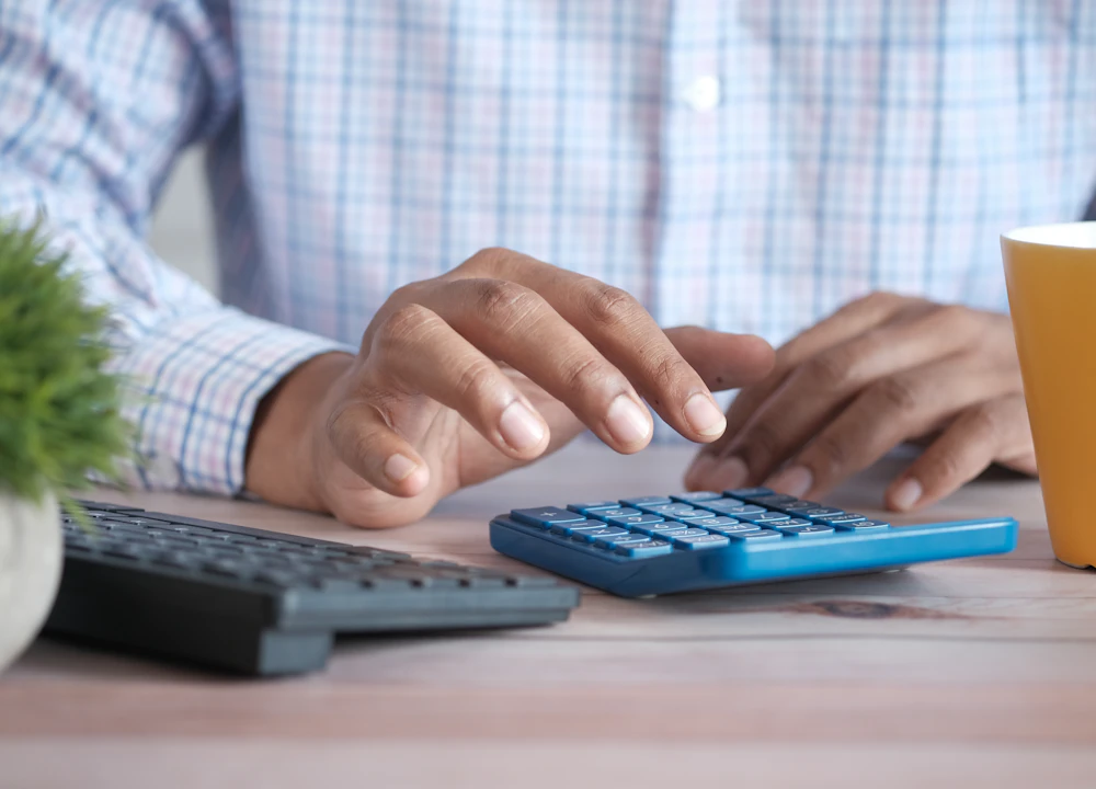 Hands working through invoices with a calculator