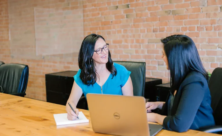 Two people reviewing work together at a table