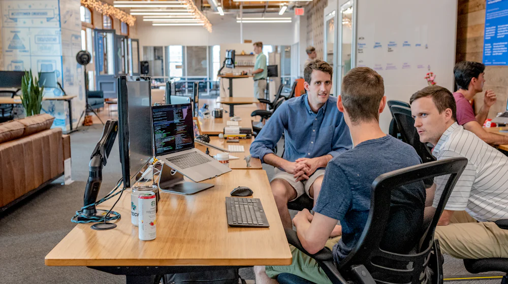 An open-plan office floor with teams at work